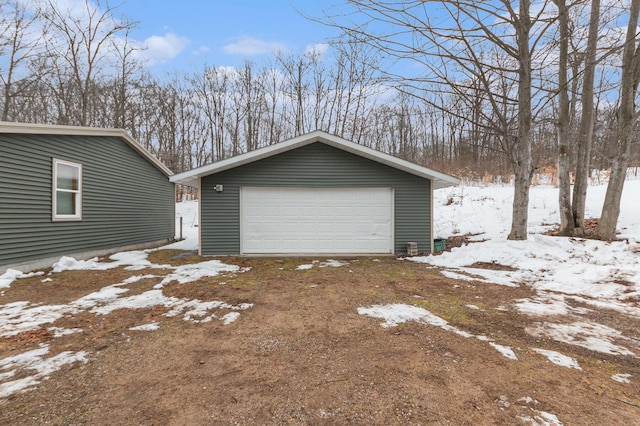 snow covered garage featuring a garage