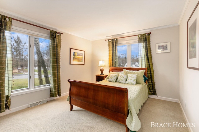 bedroom with carpet floors, visible vents, crown molding, and baseboards