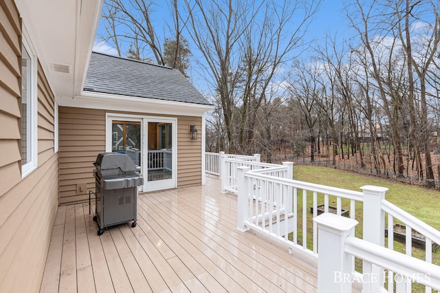 wooden terrace featuring fence, grilling area, and a lawn