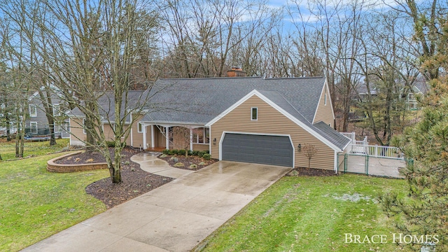 view of front of house with a shingled roof, concrete driveway, an attached garage, fence, and a front lawn