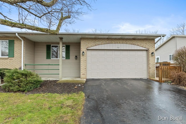 ranch-style house with an attached garage, driveway, and brick siding