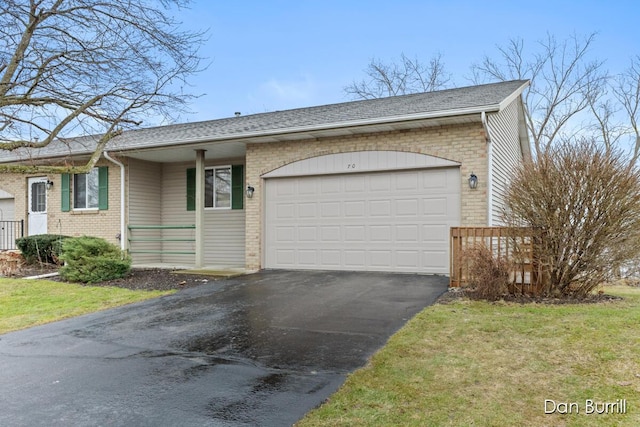 ranch-style home featuring brick siding, aphalt driveway, roof with shingles, an attached garage, and a front yard