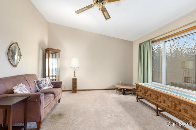 living area with a ceiling fan, light colored carpet, and baseboards