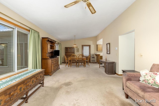 living area with lofted ceiling, light carpet, and ceiling fan