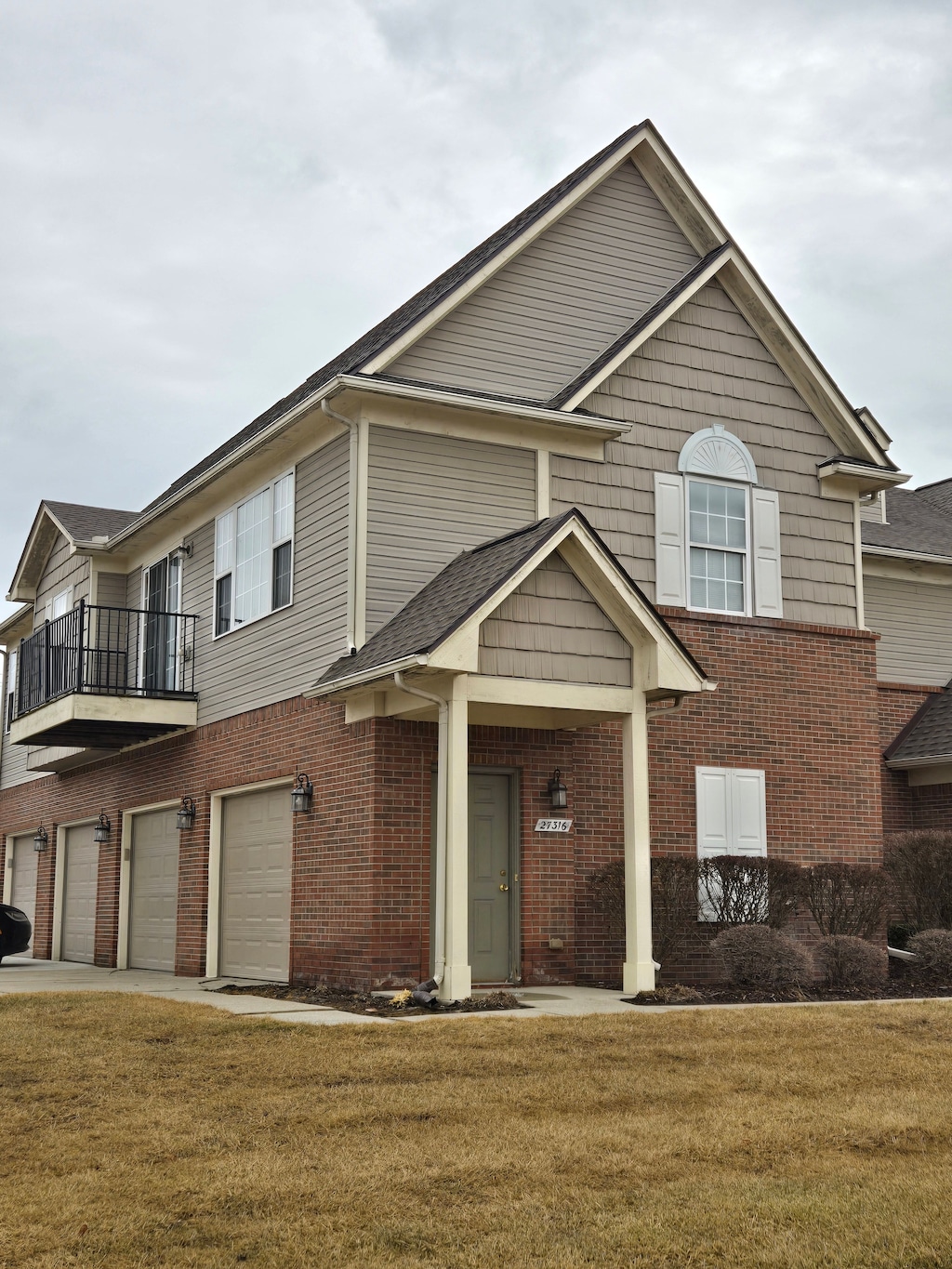 view of front of home featuring a garage, a front yard, and brick siding