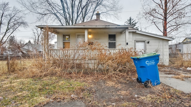 view of front of property with a porch and fence