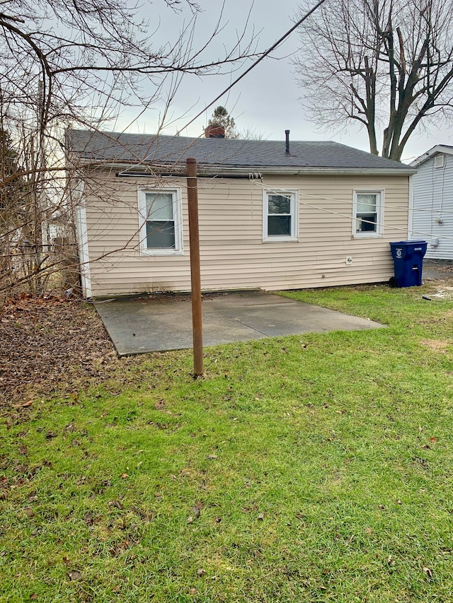 back of house with a patio and a lawn