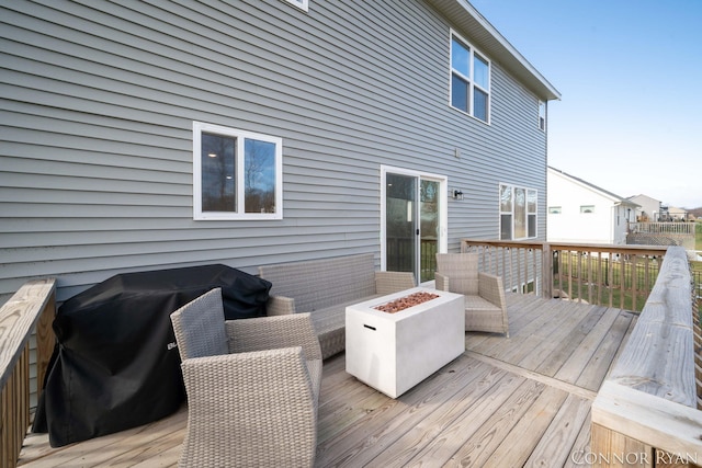 wooden deck with an outdoor fire pit and a grill