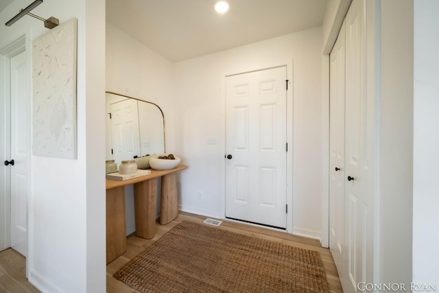 interior space featuring baseboards, visible vents, wood finished floors, and vanity