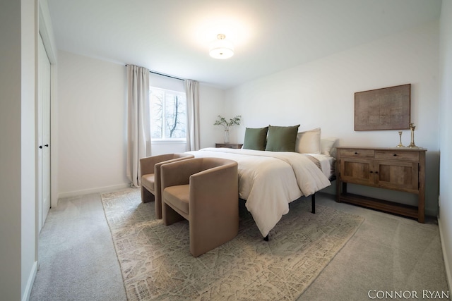 bedroom featuring baseboards and light colored carpet