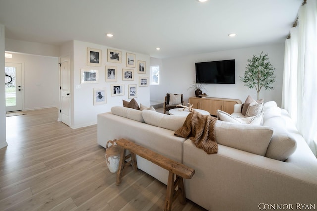 living area featuring baseboards, light wood-type flooring, and recessed lighting