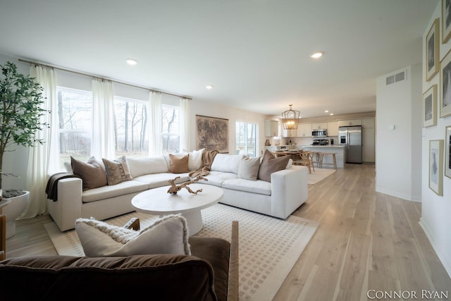 living area with light wood finished floors, baseboards, visible vents, and recessed lighting