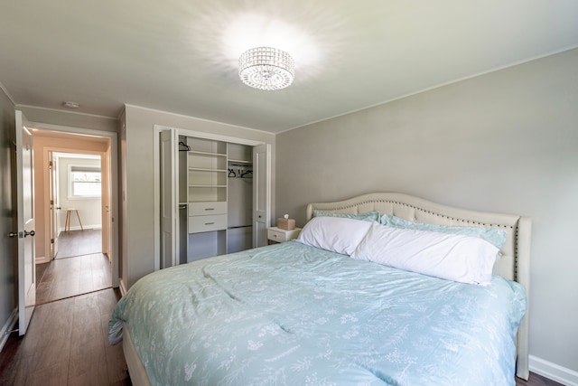 bedroom featuring wood-type flooring, baseboards, a closet, and ornamental molding