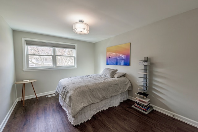 bedroom with dark wood-style flooring, visible vents, and baseboards