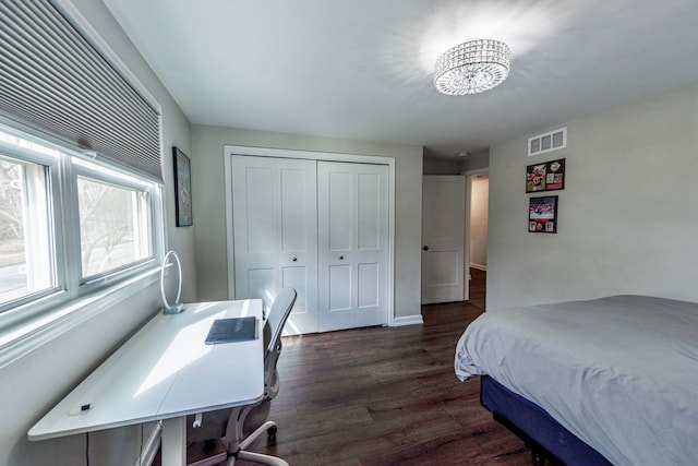 bedroom with a closet, dark wood-style flooring, and visible vents