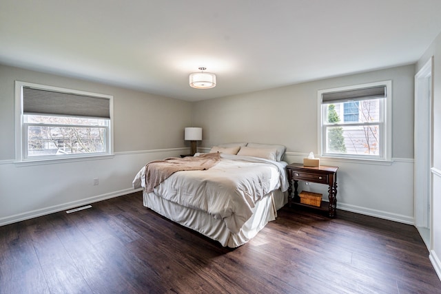 bedroom featuring dark wood-type flooring, visible vents, and baseboards