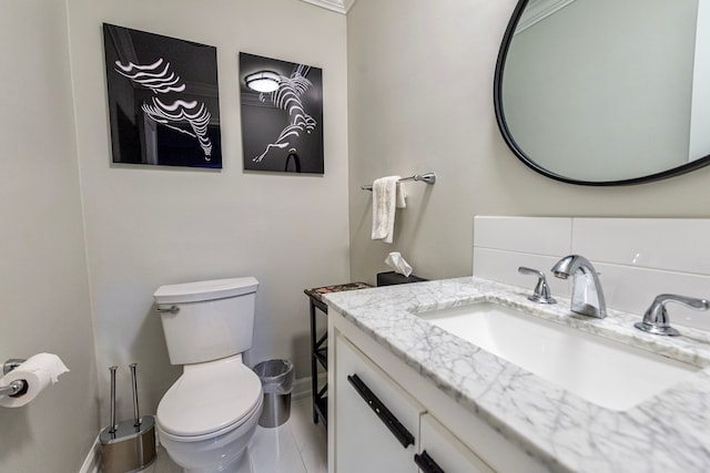 bathroom with baseboards, vanity, and toilet