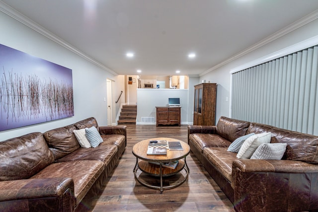 living room with stairs, visible vents, wood finished floors, and ornamental molding