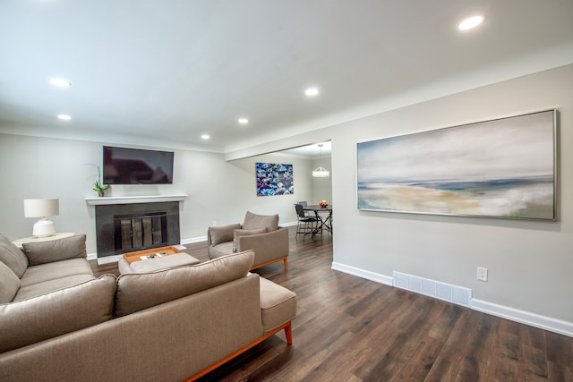 living room with recessed lighting, visible vents, baseboards, dark wood-style floors, and a glass covered fireplace