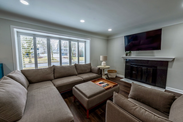 living room featuring recessed lighting, baseboards, wood finished floors, and a high end fireplace