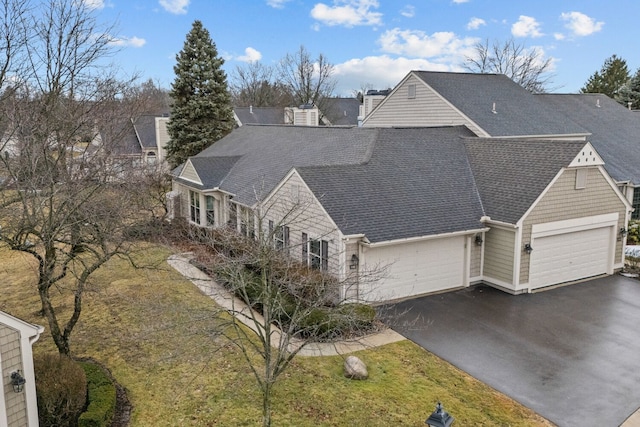 view of front of property featuring driveway, a shingled roof, and an attached garage