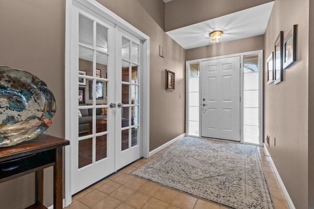 tiled foyer entrance featuring french doors and baseboards