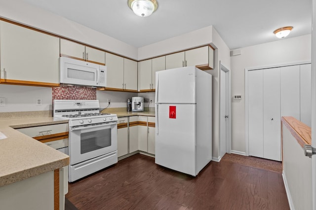 kitchen with white appliances, dark wood-style flooring, baseboards, white cabinets, and light countertops