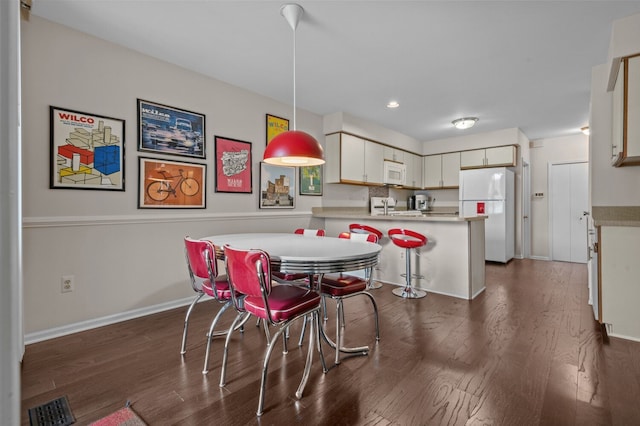 dining area with visible vents, dark wood finished floors, and baseboards