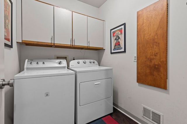 washroom with cabinet space, baseboards, visible vents, and washing machine and clothes dryer