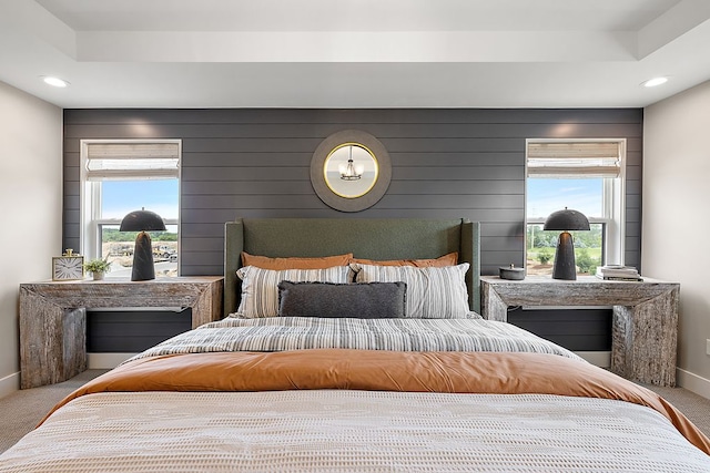 carpeted bedroom featuring recessed lighting, a raised ceiling, and baseboards