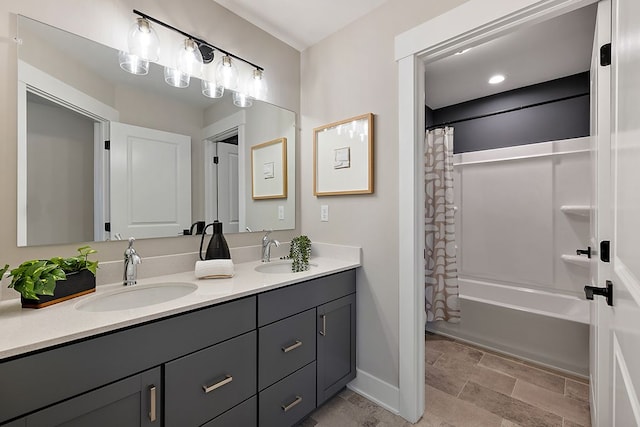 full bath featuring a sink, baseboards, shower / bath combo with shower curtain, and double vanity