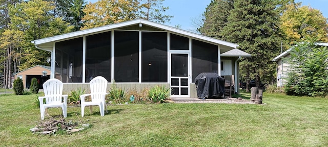 rear view of property with a sunroom and a yard