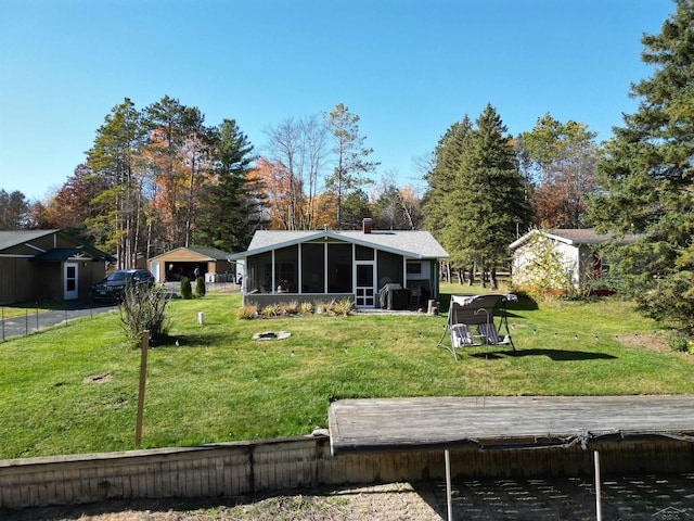 back of property featuring a sunroom, a yard, and a chimney