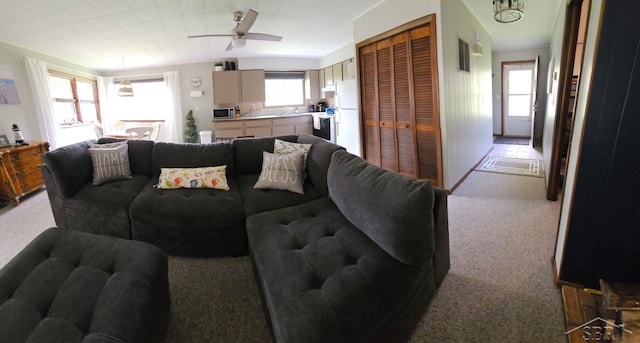 living area featuring a ceiling fan, light carpet, and visible vents