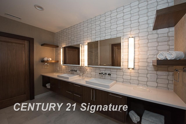 full bath featuring double vanity, backsplash, a sink, and visible vents