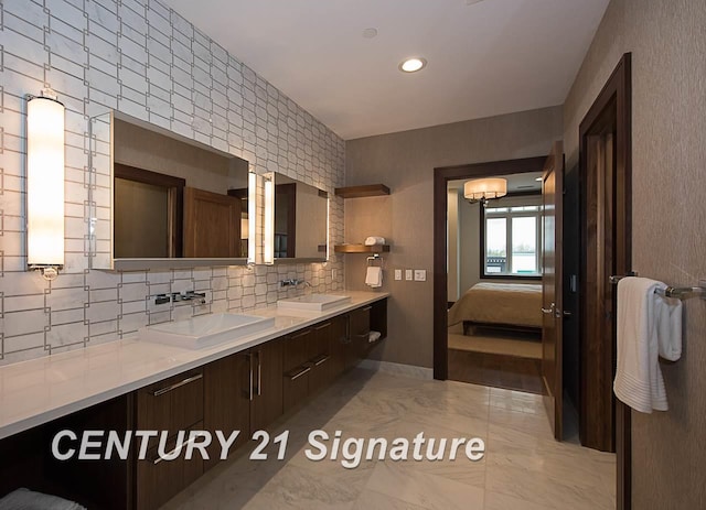 full bathroom featuring double vanity, ensuite bath, backsplash, and a sink