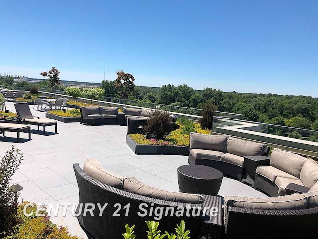 view of patio with outdoor lounge area and a view of trees