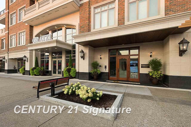 property entrance featuring brick siding and french doors