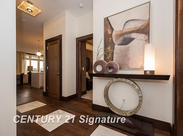 hallway featuring baseboards and wood finished floors