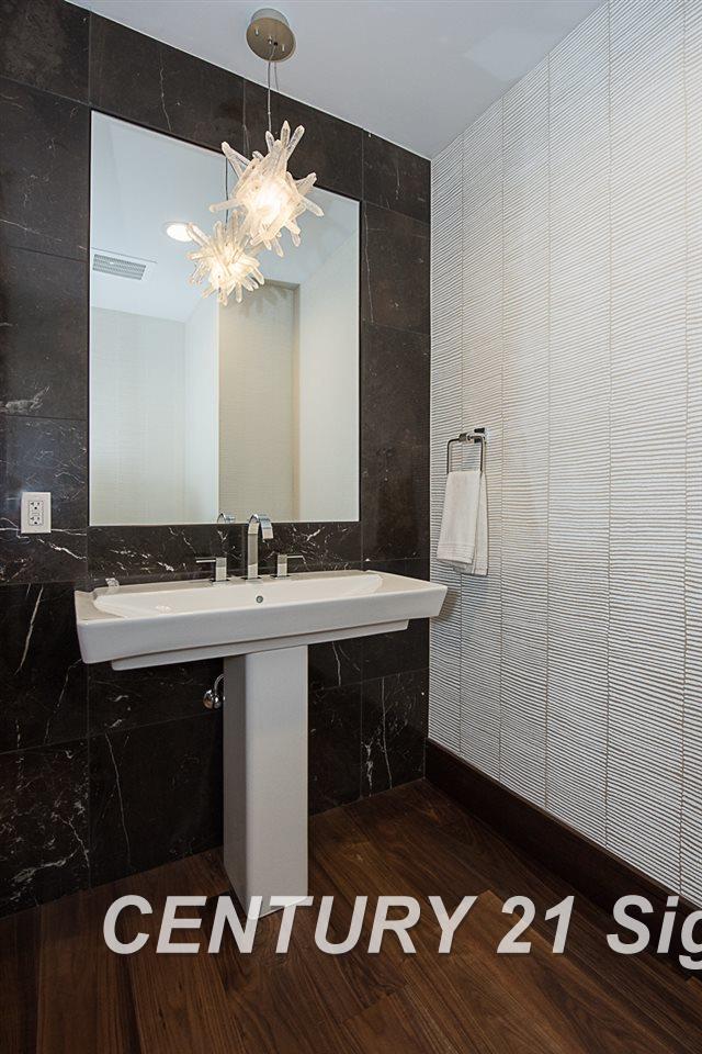 110 E Main St, Midland, MI 48640 - bathroom featuring tile walls and a chandelier