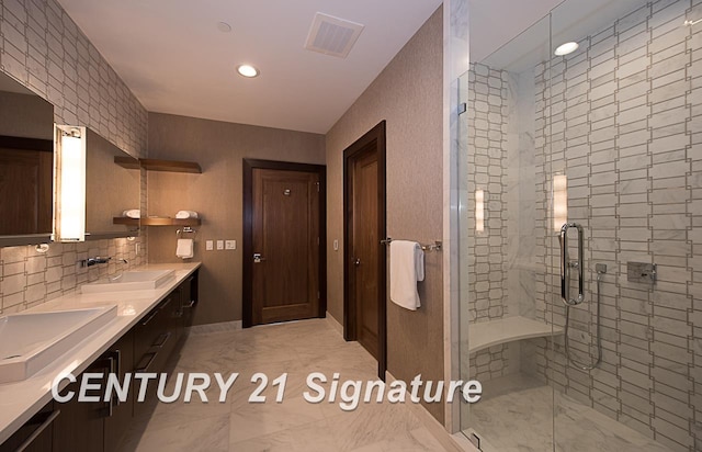 full bathroom with marble finish floor, visible vents, a sink, and a shower stall