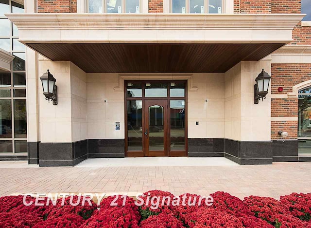 property entrance featuring french doors and brick siding