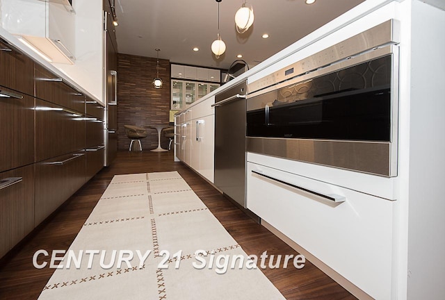 kitchen featuring dark wood-style floors, light countertops, wall oven, dark brown cabinets, and modern cabinets