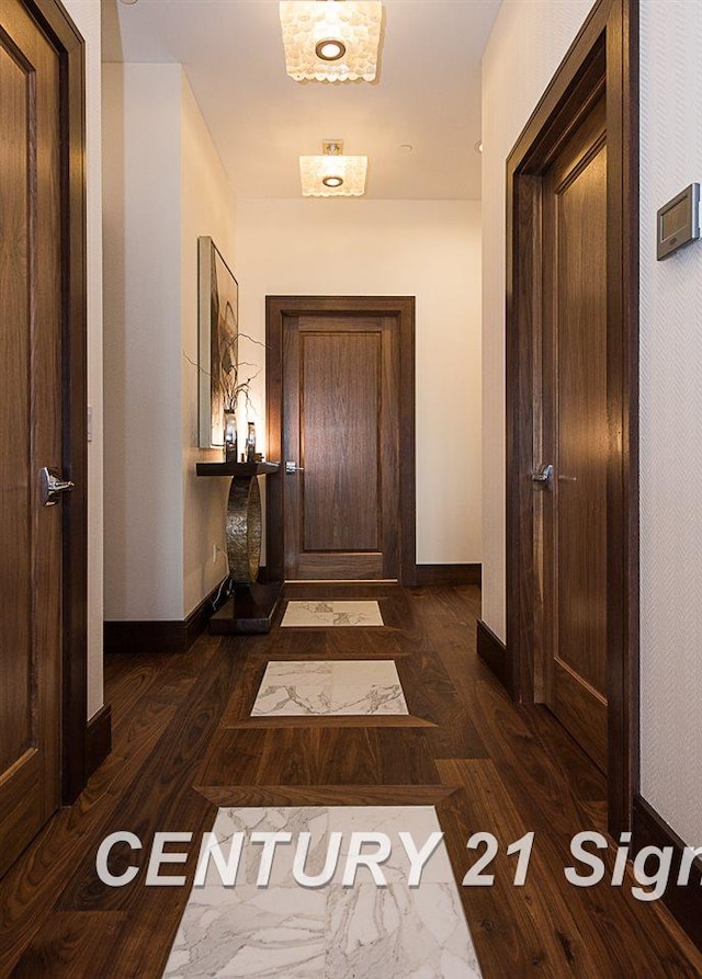 corridor with baseboards and dark wood-style flooring