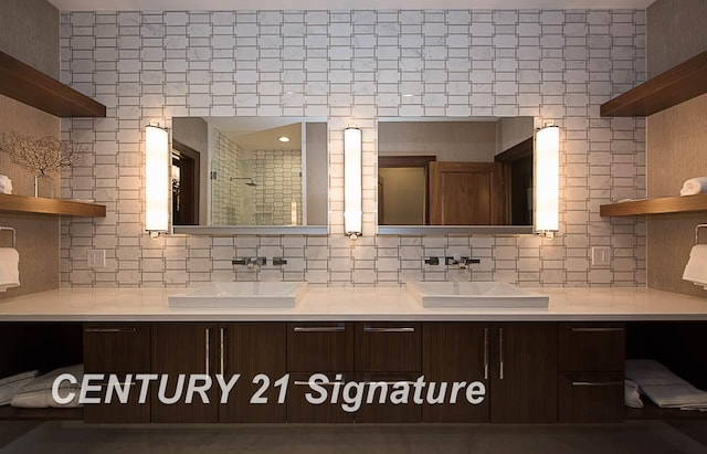 bathroom featuring double vanity, backsplash, a sink, and tiled shower