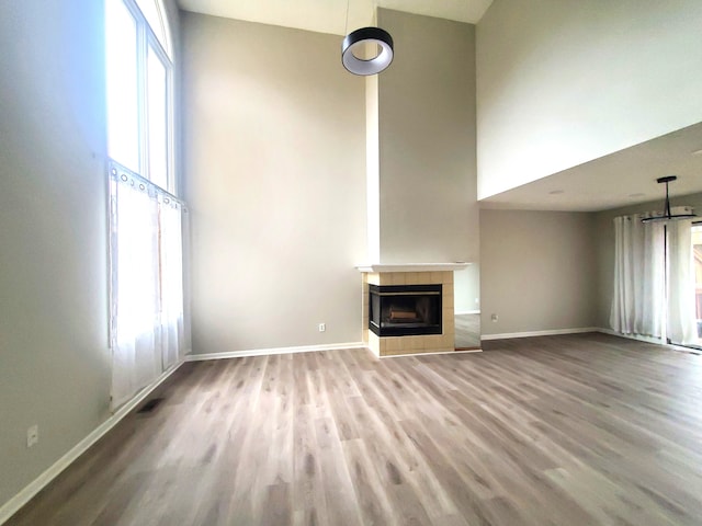 unfurnished living room with a healthy amount of sunlight, wood finished floors, and a fireplace