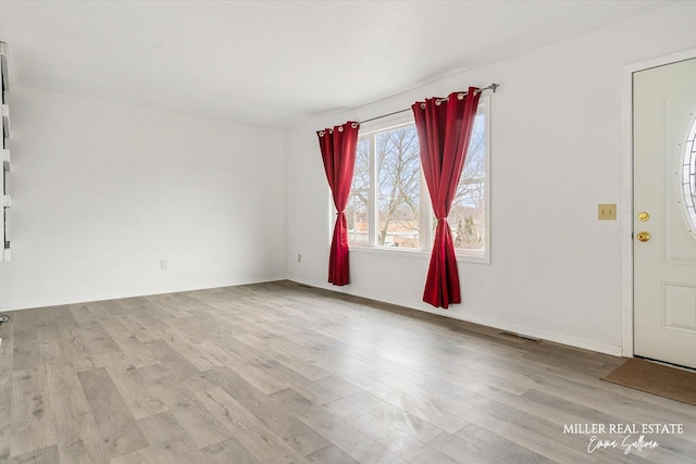 interior space featuring wood finished floors, visible vents, and baseboards