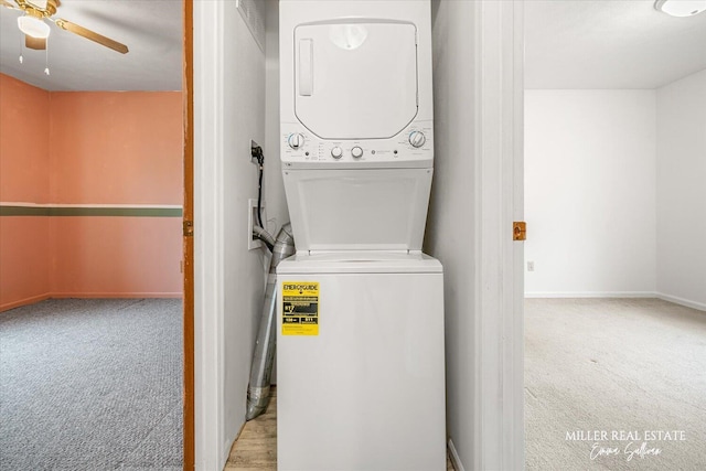 laundry room with laundry area, baseboards, a ceiling fan, stacked washer and clothes dryer, and carpet