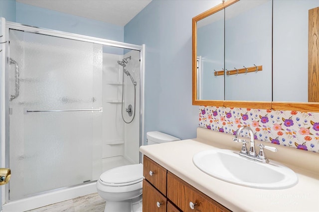 bathroom with wood finished floors, a stall shower, vanity, and toilet