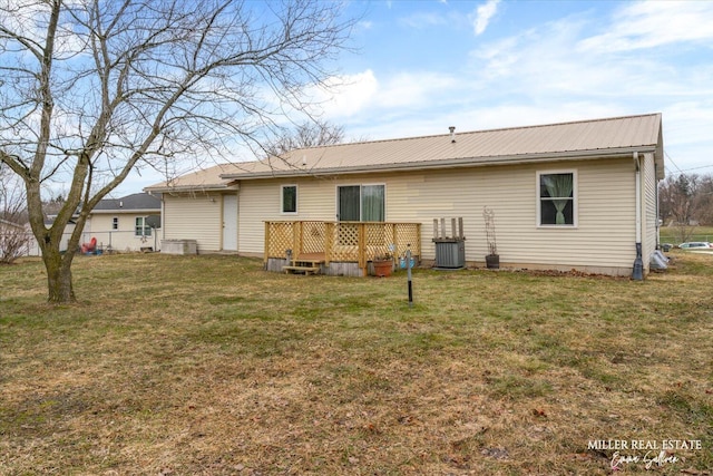 rear view of property with a wooden deck, metal roof, and a yard